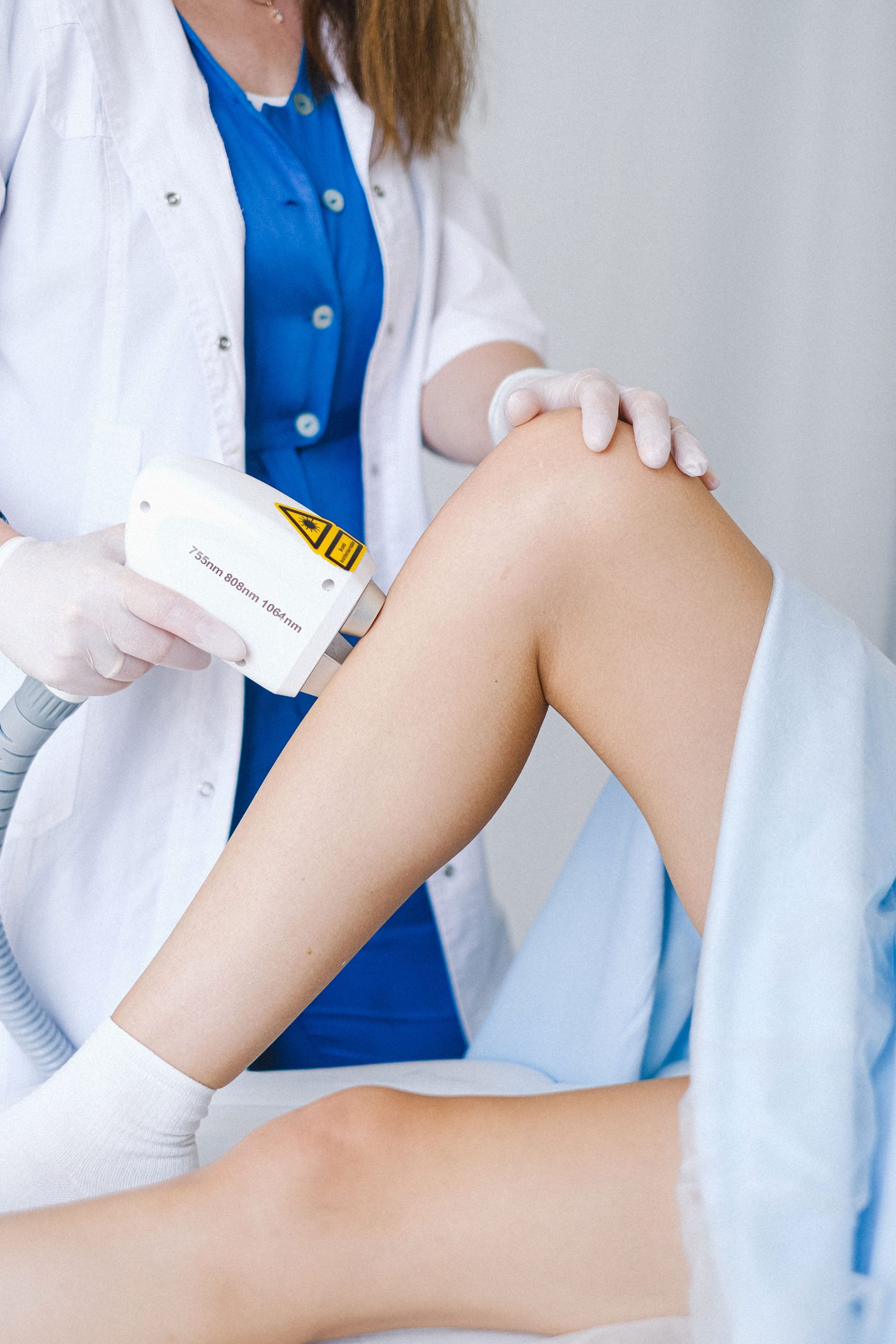 Practitioner performing laser hair removal on a female client